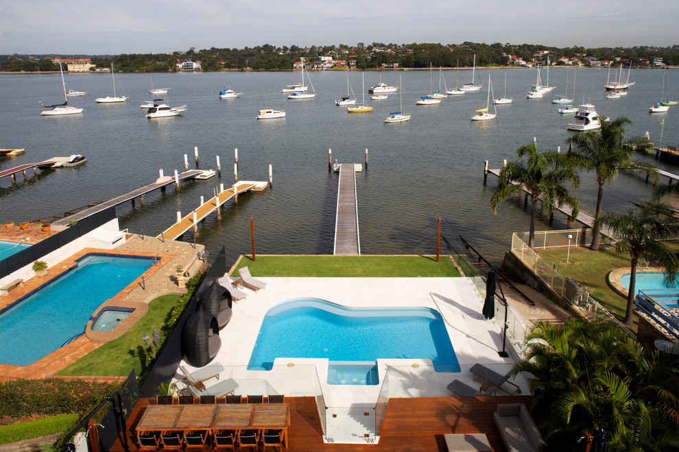 Großer Moderner Schwimmteich hinter dem Haus in individueller Form mit Natursteinplatten in Sydney