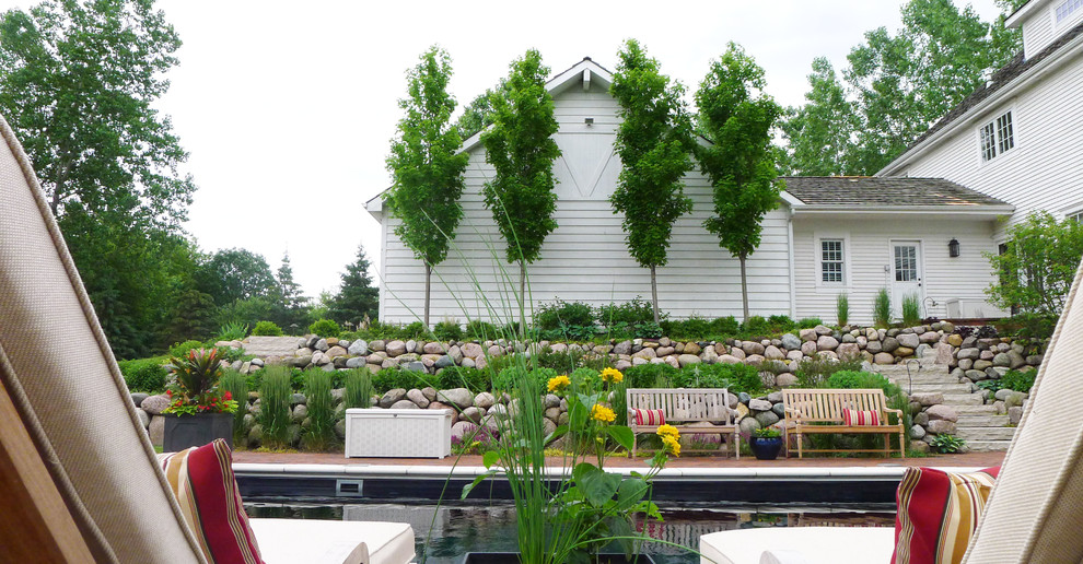 На фото: прямоугольный бассейн среднего размера на заднем дворе в стиле кантри с мощением клинкерной брусчаткой
