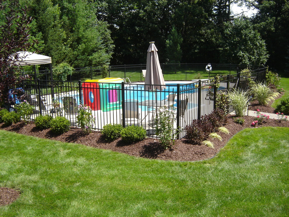 Example of a mid-sized classic backyard stamped concrete aboveground pool design in Detroit