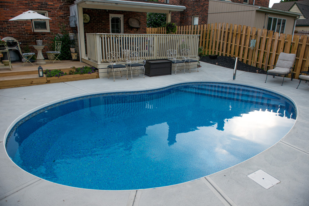 Foto di una piccola piscina contemporanea a "C" dietro casa con lastre di cemento