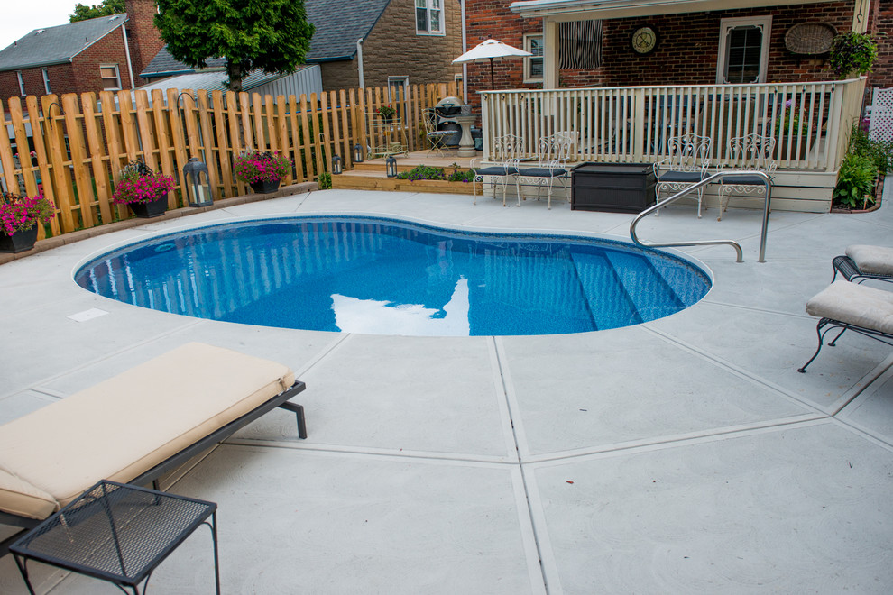 На фото: маленький бассейн в форме фасоли на заднем дворе в современном стиле с покрытием из бетонных плит для на участке и в саду
