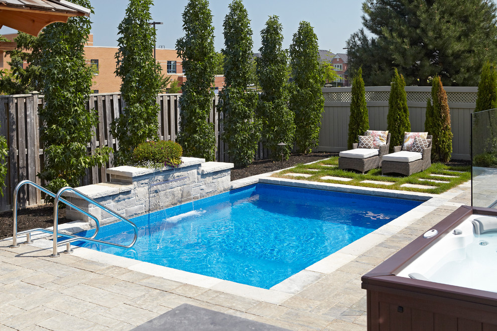 Imagen de piscina con fuente natural actual pequeña rectangular en patio trasero