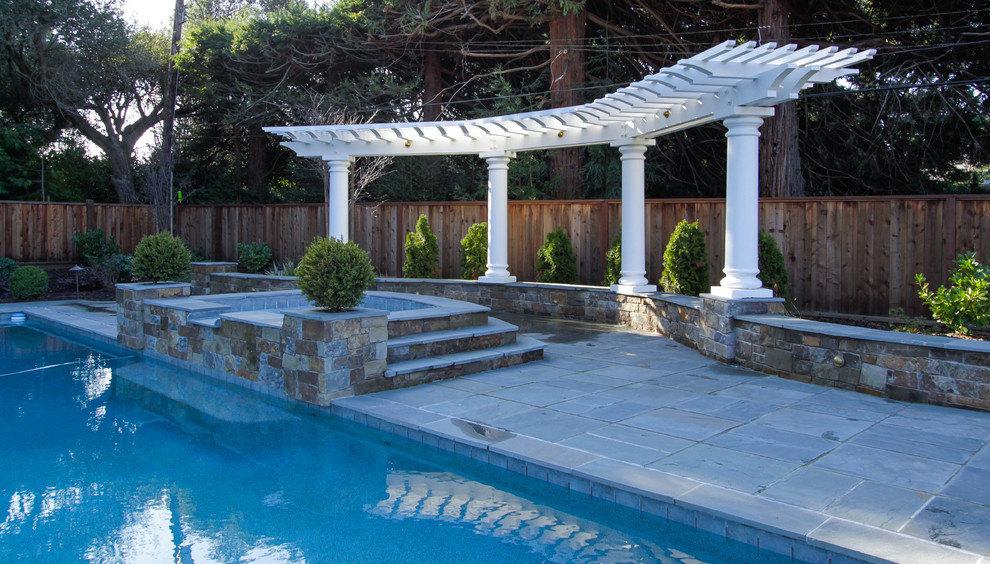 Diseño de piscina natural clásica grande a medida en patio trasero