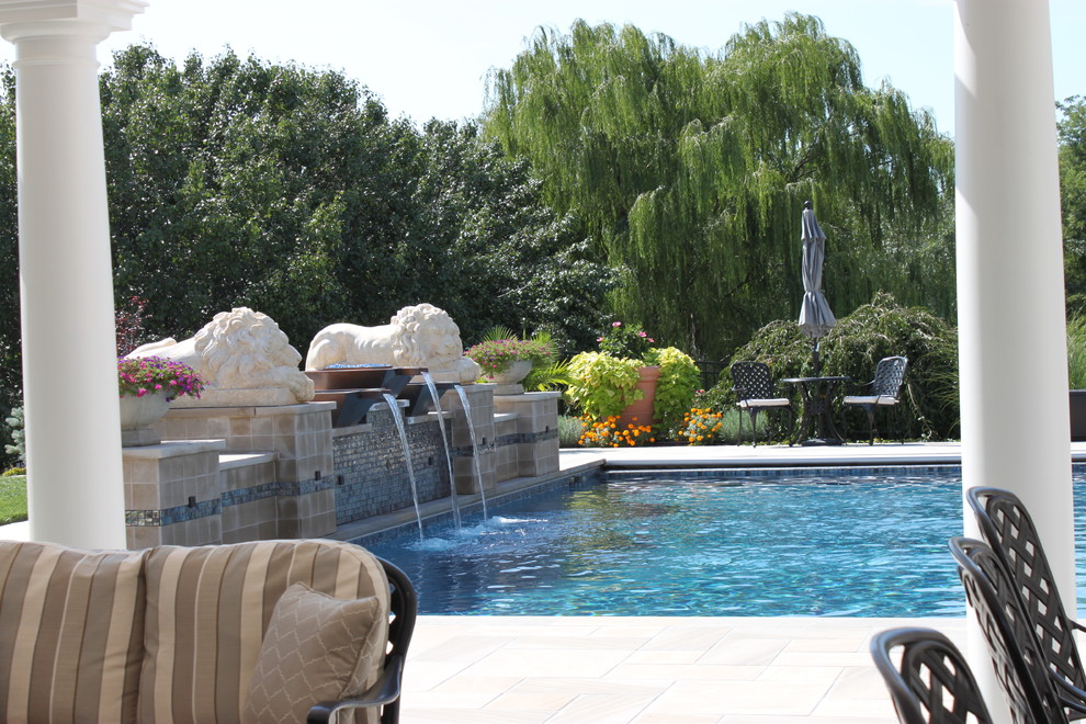 Idee per una grande piscina mediterranea rettangolare dietro casa con fontane e pavimentazioni in pietra naturale