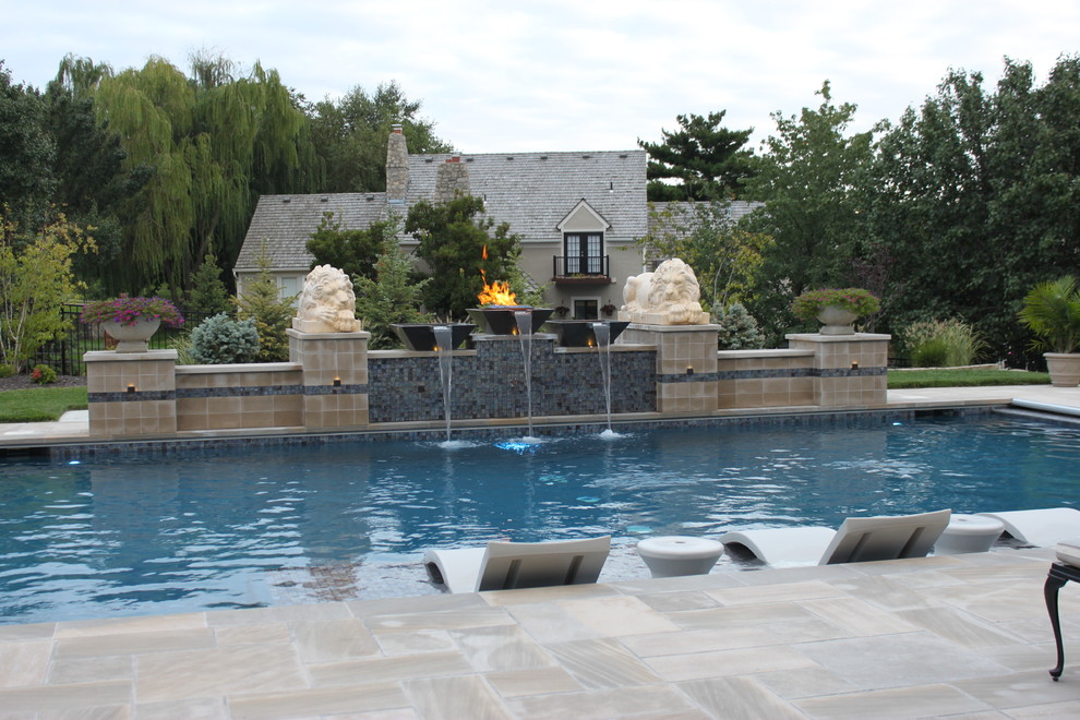 На фото: большой прямоугольный бассейн на заднем дворе в средиземноморском стиле с фонтаном и покрытием из каменной брусчатки с