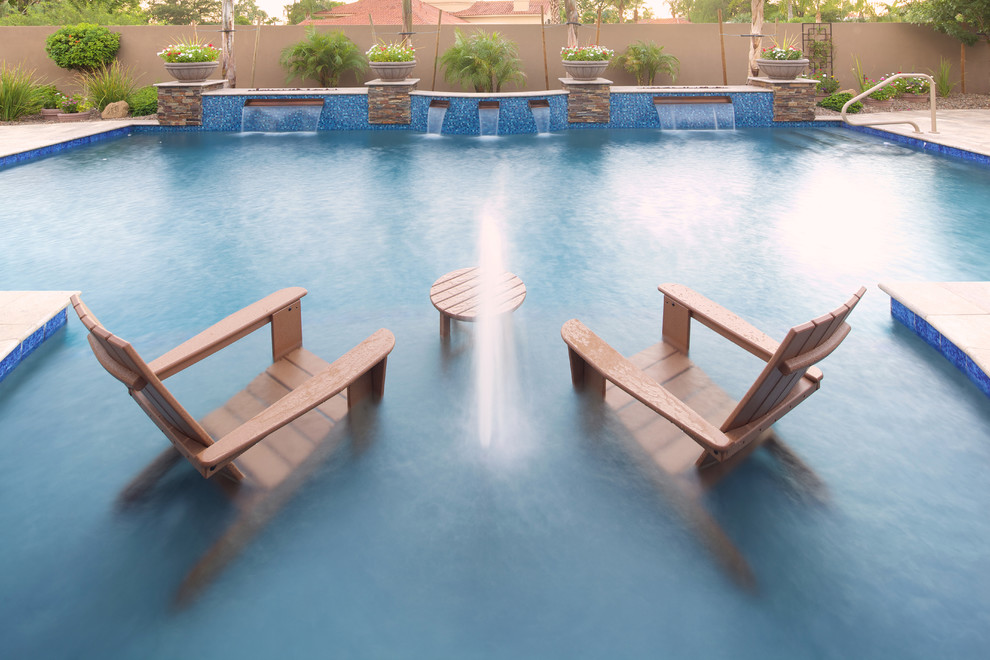 Modelo de piscina natural mediterránea grande a medida en patio trasero con adoquines de piedra natural