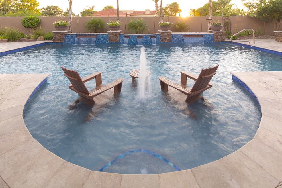 Esempio di una grande piscina naturale mediterranea personalizzata dietro casa con pavimentazioni in pietra naturale