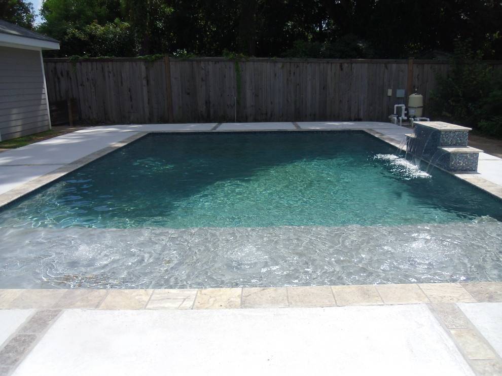 Medium sized modern back rectangular natural swimming pool in New Orleans with a water feature and decking.