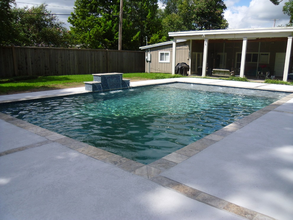 Modelo de piscina con fuente natural minimalista de tamaño medio rectangular en patio trasero con entablado
