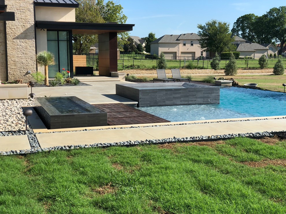 Großer Moderner Pool hinter dem Haus in L-Form mit Betonplatten in Houston