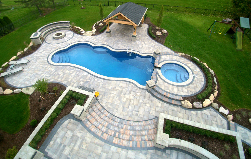 Стильный дизайн: огромный наземный бассейн произвольной формы на заднем дворе в классическом стиле с джакузи и покрытием из плитки - последний тренд