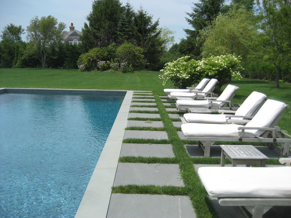 Immagine di una grande piscina monocorsia tradizionale rettangolare dietro casa con pavimentazioni in pietra naturale