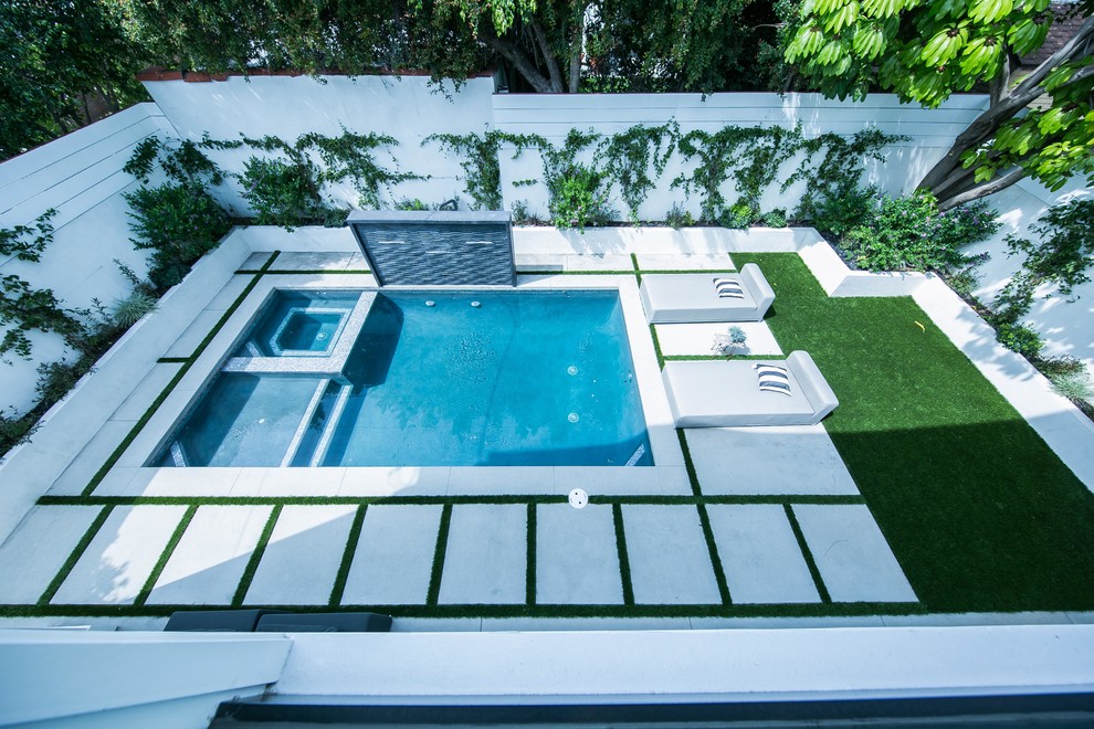 Ejemplo de piscinas y jacuzzis elevados de estilo de casa de campo de tamaño medio en forma de L en patio trasero con adoquines de hormigón