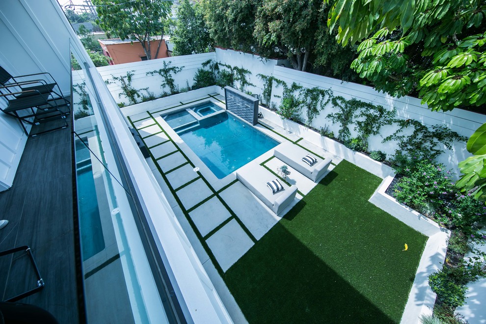 Immagine di una piscina fuori terra country a "L" di medie dimensioni e dietro casa con una vasca idromassaggio e pavimentazioni in cemento