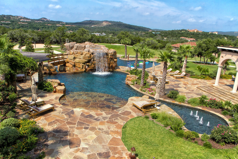 Huge elegant backyard stone and custom-shaped pool fountain photo in Austin
