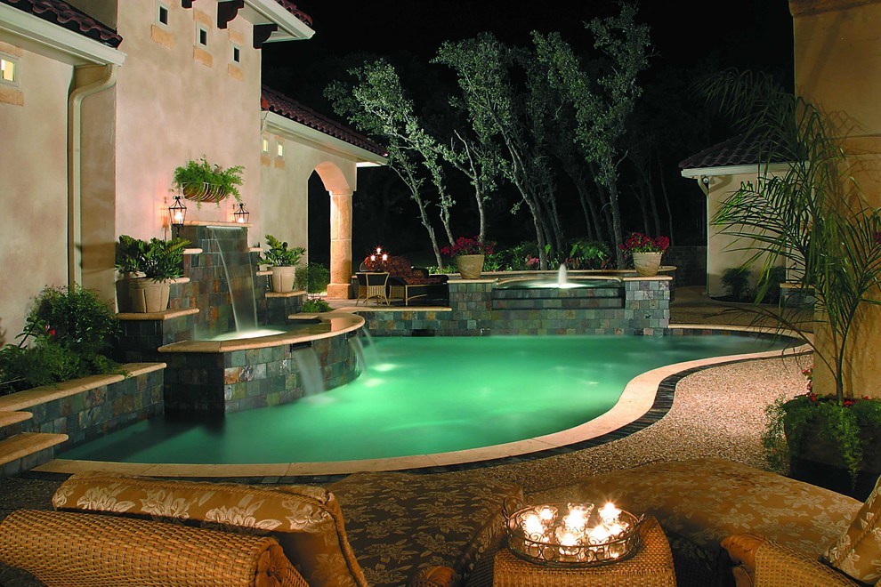 Ejemplo de piscina con fuente mediterránea de tamaño medio a medida en patio trasero con adoquines de piedra natural