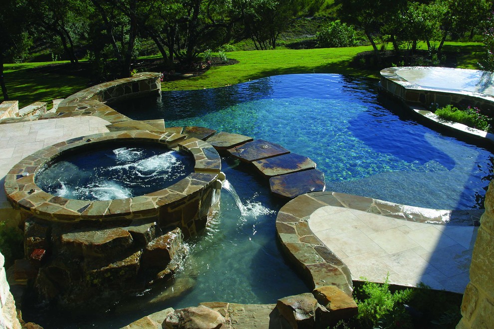 Idee per una piscina a sfioro infinito design personalizzata di medie dimensioni e dietro casa con una vasca idromassaggio e pavimentazioni in pietra naturale