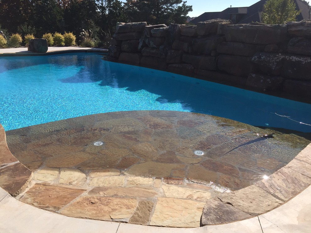Foto di una piscina naturale tropicale personalizzata dietro casa con una vasca idromassaggio