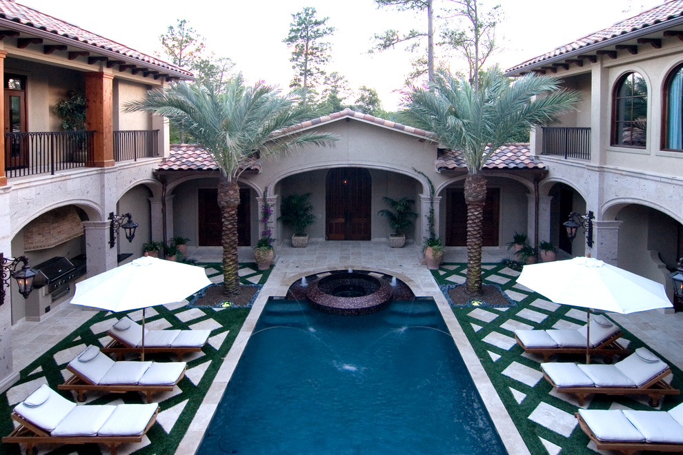 Ejemplo de casa de la piscina y piscina alargada clásica grande rectangular en patio con adoquines de piedra natural