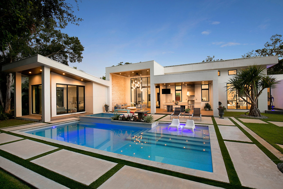 Modelo de casa de la piscina y piscina contemporánea, rectangular, en patio trasero, con losas de hormigón