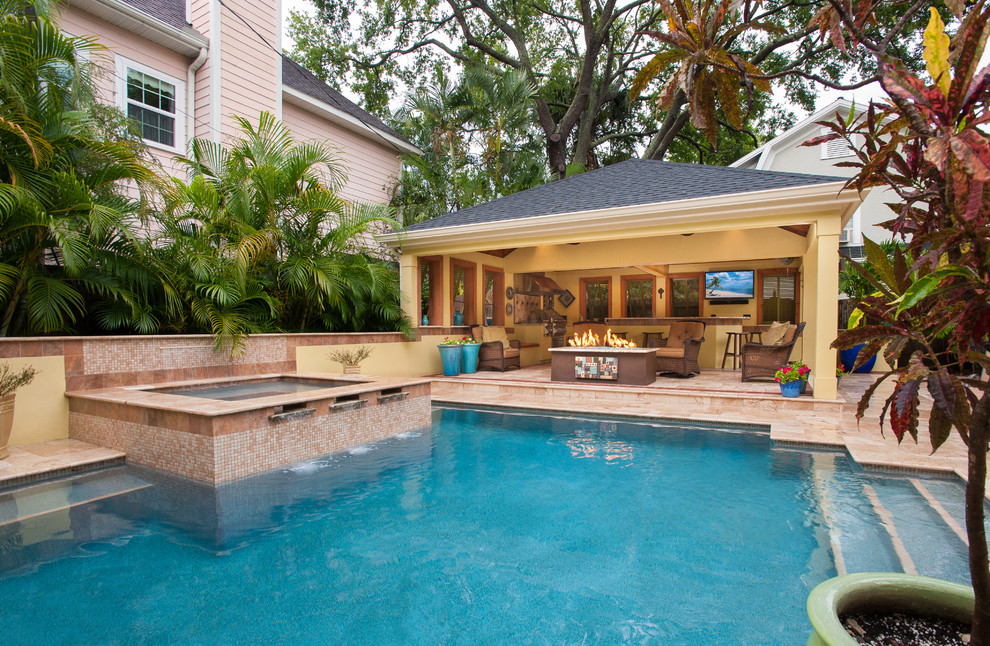 Großer Mediterraner Pool hinter dem Haus in rechteckiger Form mit Natursteinplatten in Tampa