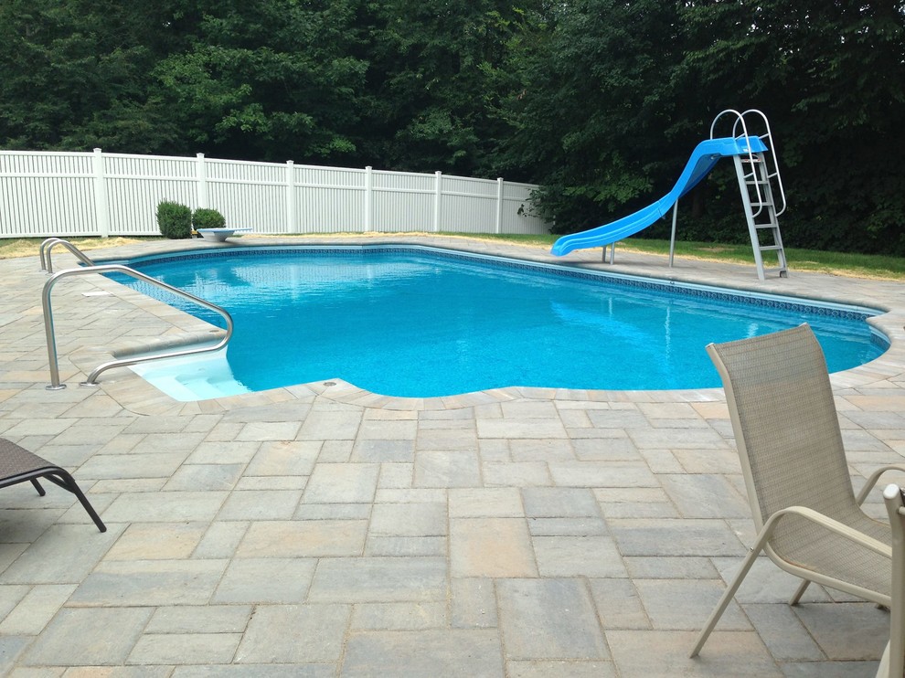 Esempio di una piscina classica personalizzata dietro casa con un acquascivolo e pavimentazioni in cemento