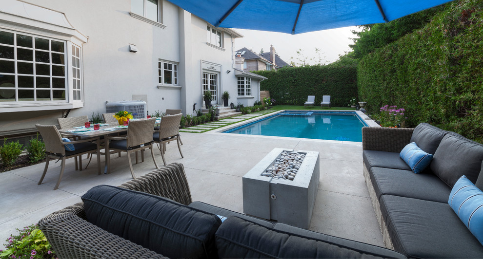Immagine di una piscina monocorsia design rettangolare di medie dimensioni e dietro casa con una vasca idromassaggio e pavimentazioni in cemento