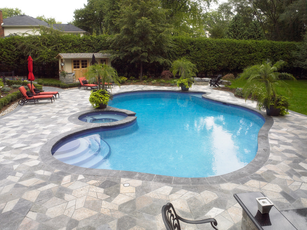 Esempio di una piscina monocorsia contemporanea personalizzata di medie dimensioni e dietro casa con una vasca idromassaggio e pavimentazioni in cemento
