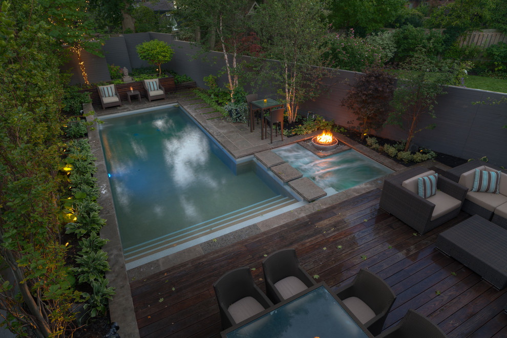 Immagine di una piscina design rettangolare dietro casa con una vasca idromassaggio
