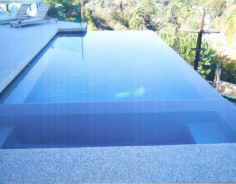 Cette image montre une petite piscine à débordement et arrière design rectangle avec un bain bouillonnant et du béton estampé.