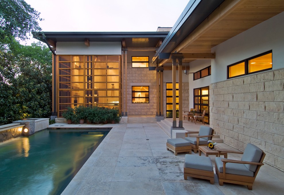 Immagine di una piscina minimal rettangolare di medie dimensioni e dietro casa con fontane e pavimentazioni in cemento