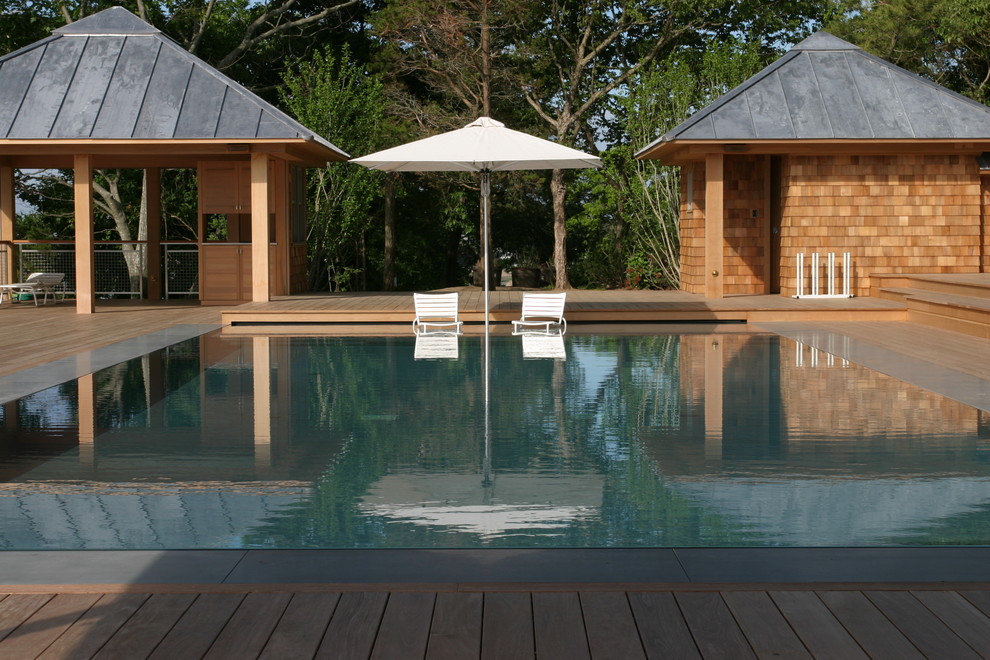 Aménagement d'une piscine bord de mer avec une terrasse en bois.