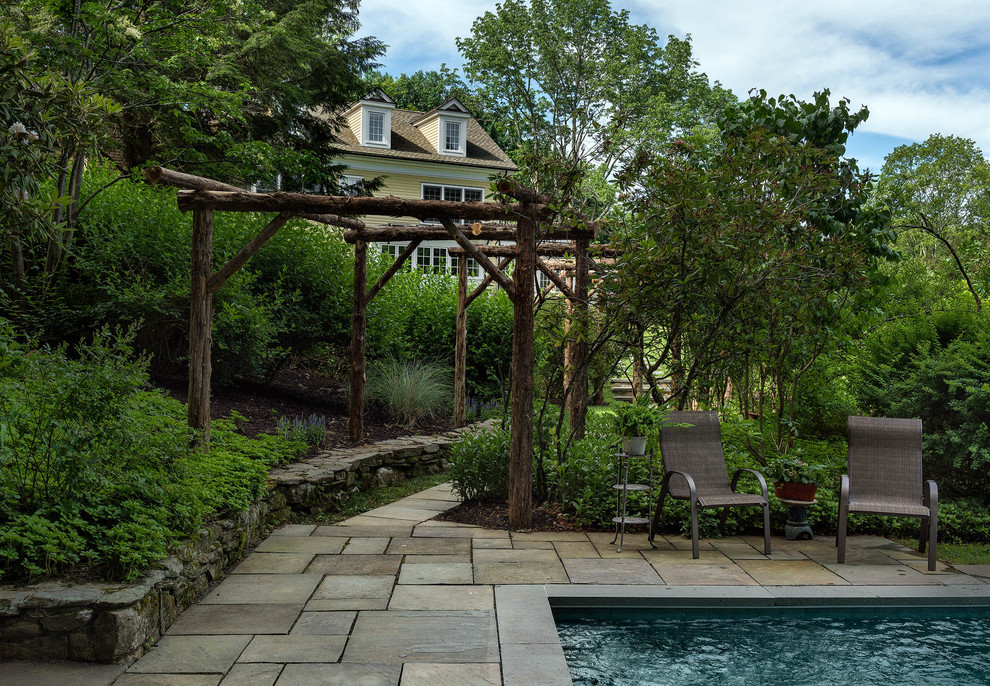 Example of a mid-sized classic backyard stone and rectangular lap pool design in Bridgeport