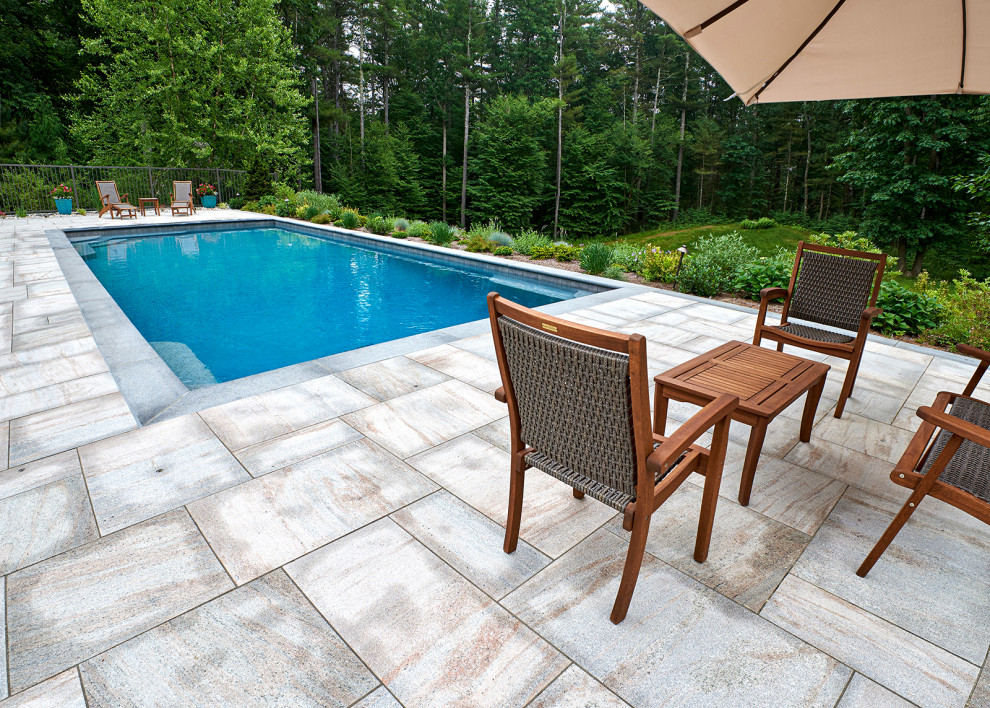 Immagine di una piscina a sfioro infinito chic rettangolare di medie dimensioni e nel cortile laterale con paesaggistica bordo piscina e pavimentazioni in pietra naturale