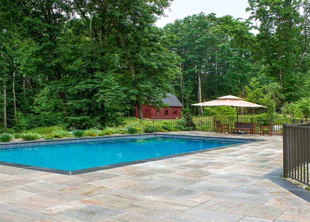 Inspiration pour un piscine avec aménagement paysager latéral traditionnel de taille moyenne et rectangle avec des pavés en pierre naturelle.