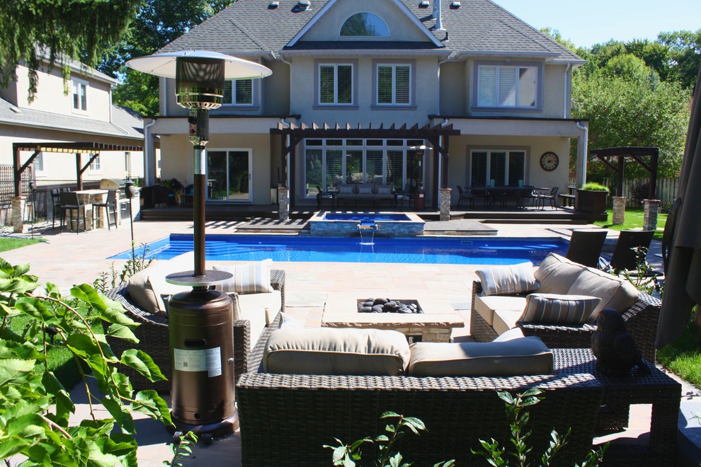 Foto di una piscina monocorsia minimal rettangolare di medie dimensioni e dietro casa con una vasca idromassaggio e pavimentazioni in pietra naturale