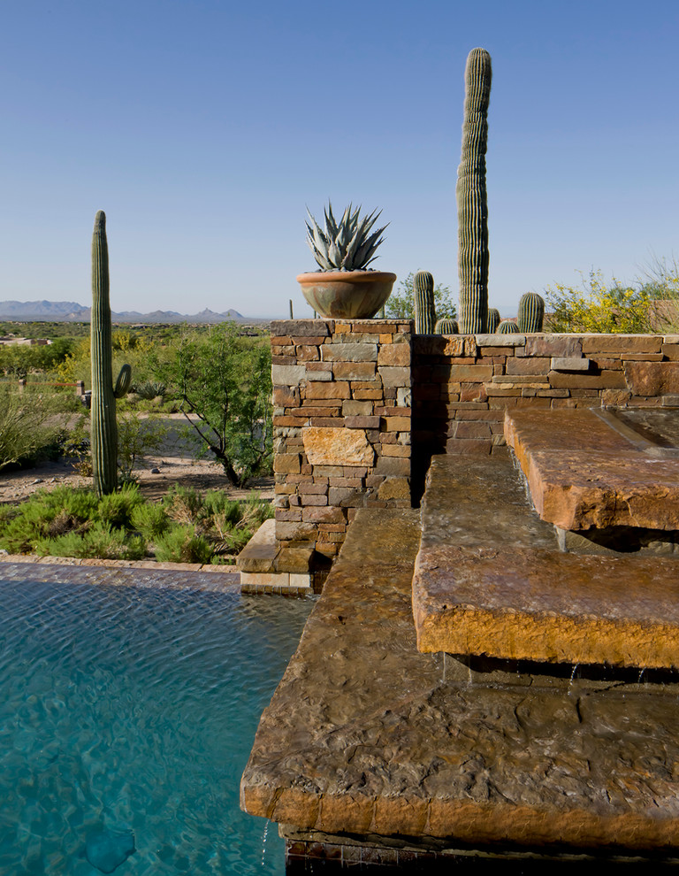 Modelo de piscina con fuente infinita mediterránea grande rectangular en patio trasero con adoquines de piedra natural