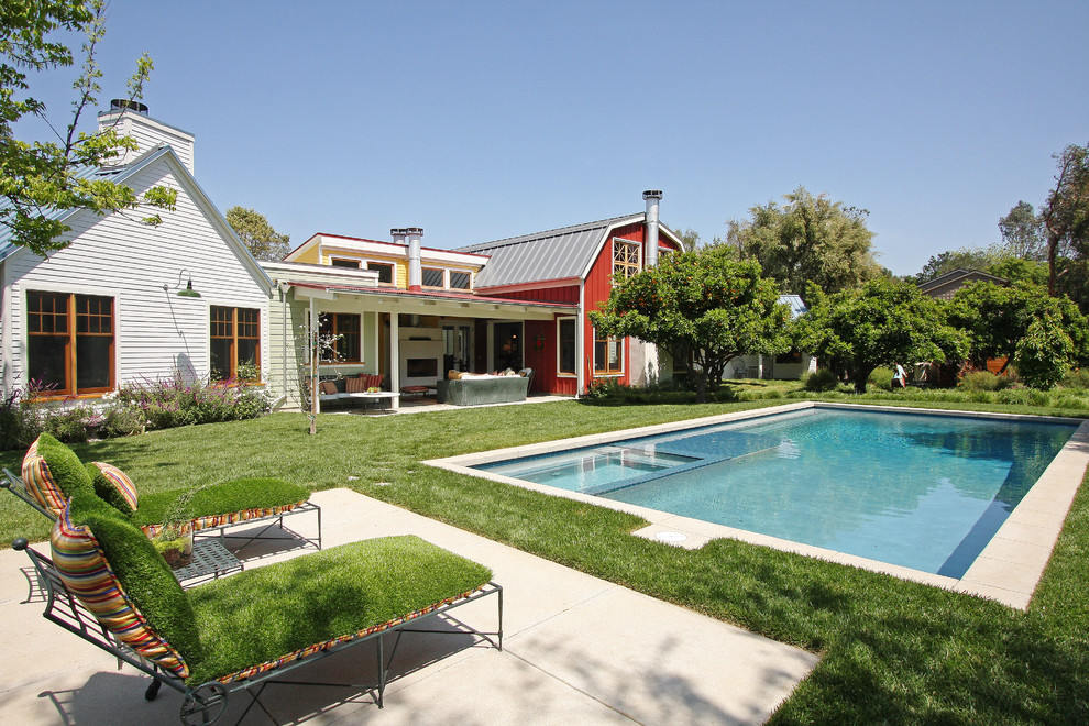 Foto de piscina de estilo de casa de campo rectangular en patio trasero con adoquines de hormigón
