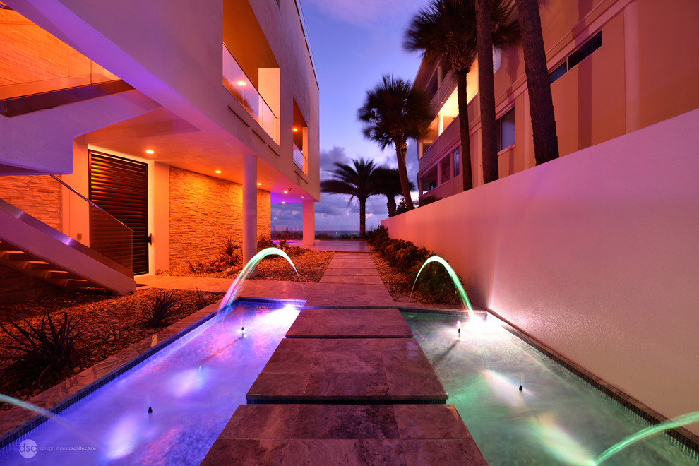 Großer Moderner Pool hinter dem Haus in rechteckiger Form mit Natursteinplatten in Tampa