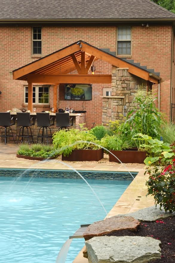 Ispirazione per una grande piscina monocorsia tradizionale rettangolare dietro casa con un acquascivolo e pavimentazioni in cemento