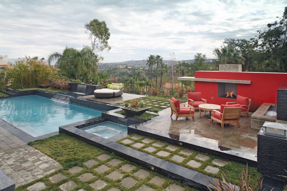 Großes Modernes Sportbecken hinter dem Haus in rechteckiger Form mit Wasserspiel und Natursteinplatten in Los Angeles