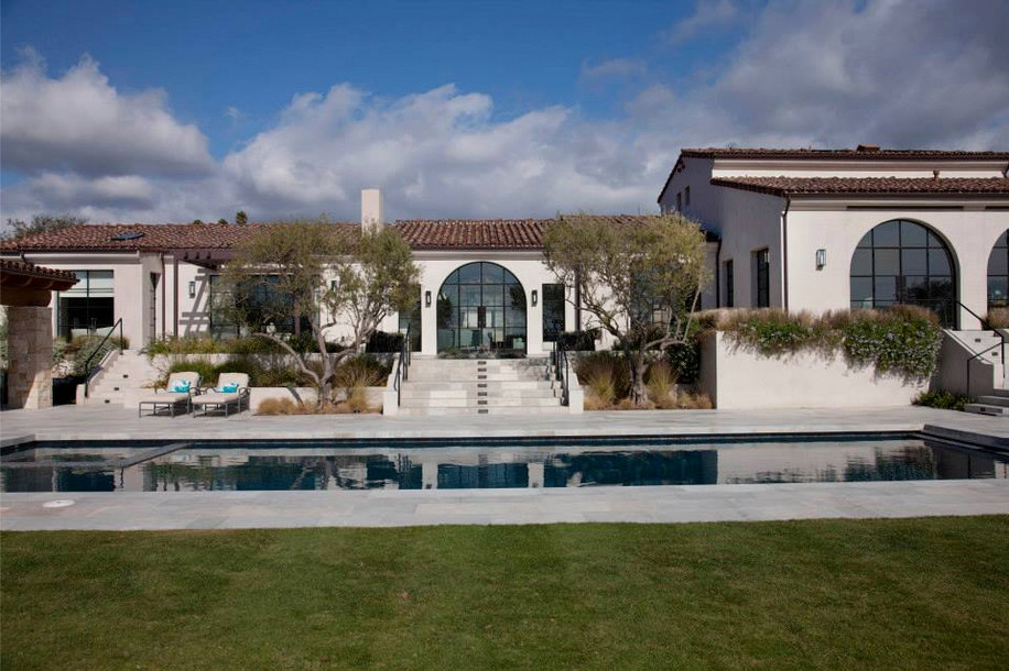 Modelo de casa de la piscina y piscina natural mediterránea grande rectangular en patio trasero con adoquines de piedra natural