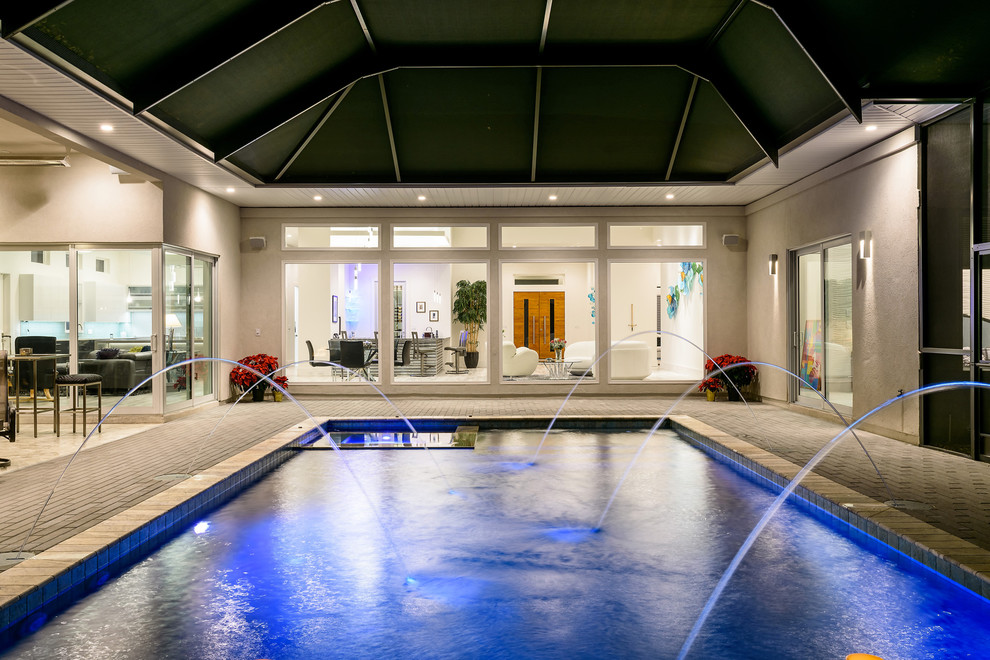 Imagen de piscina con fuente alargada contemporánea de tamaño medio rectangular en patio