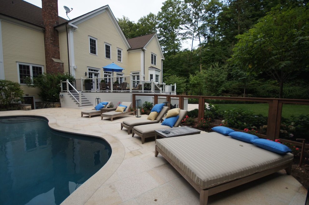 Foto di una piscina design a "C" di medie dimensioni e dietro casa con pavimentazioni in cemento