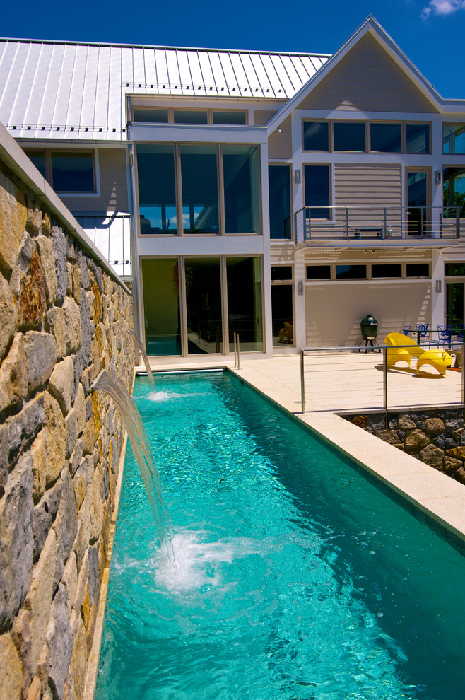 Cette image montre un couloir de nage latéral design de taille moyenne et rectangle avec un point d'eau et des pavés en pierre naturelle.
