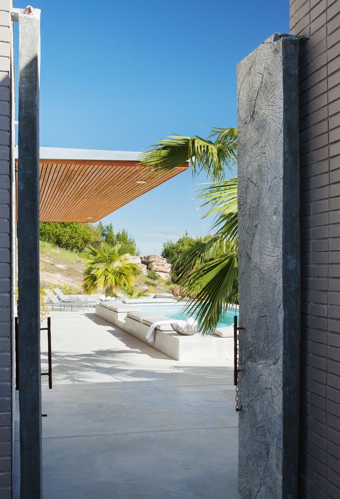 Esempio di una piscina design con lastre di cemento