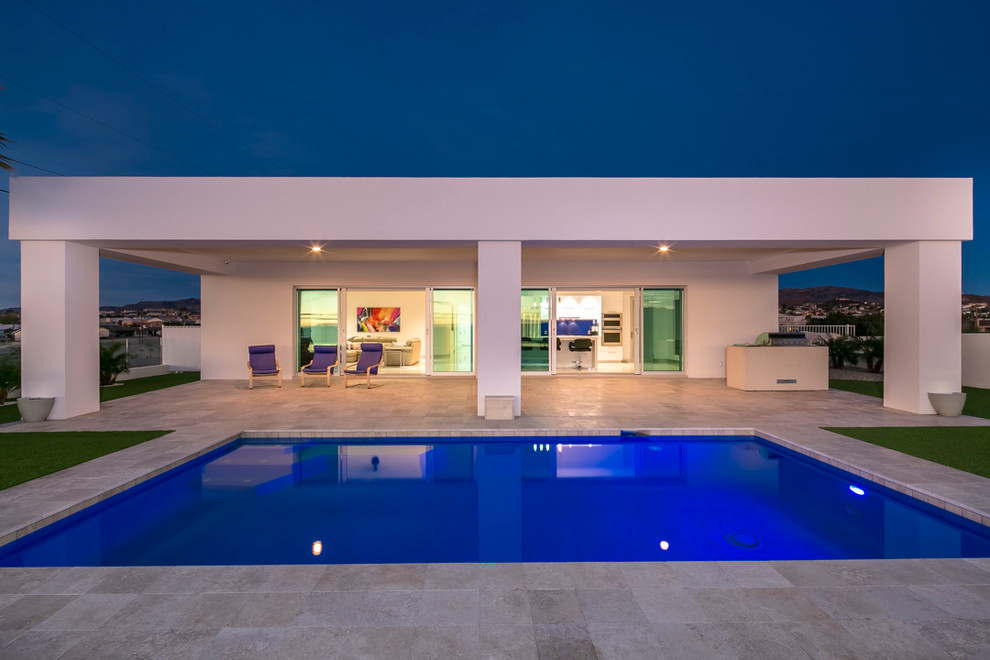 Esempio di una grande piscina design rettangolare dietro casa con piastrelle