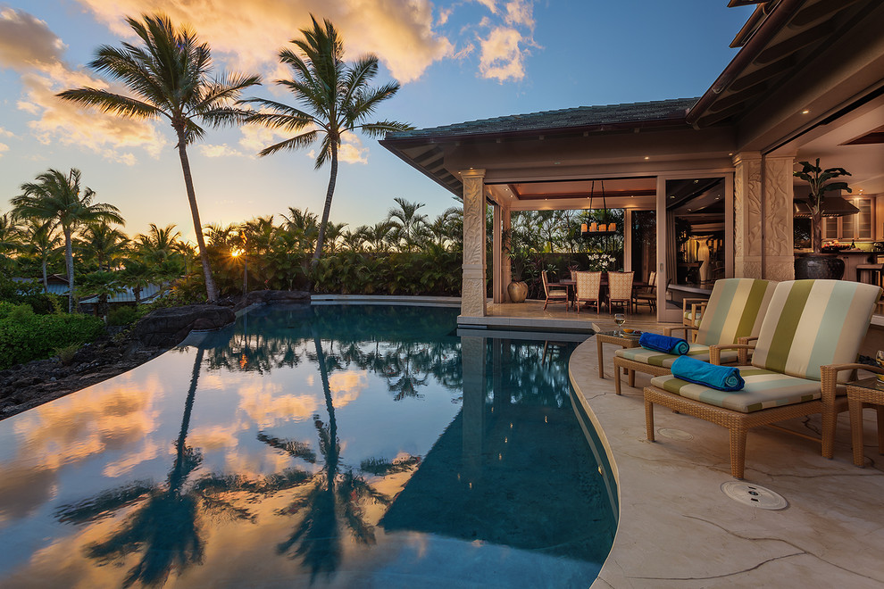 Foto de piscina con fuente tropical extra grande a medida en patio trasero con suelo de baldosas