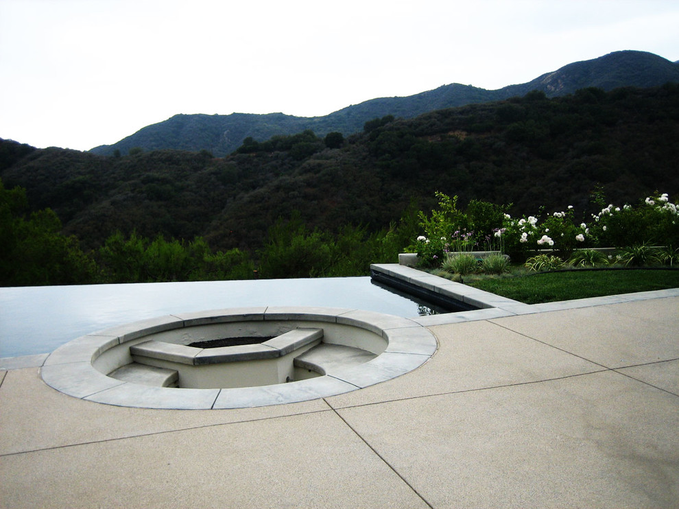 Modelo de piscina infinita minimalista pequeña a medida en patio trasero con adoquines de hormigón