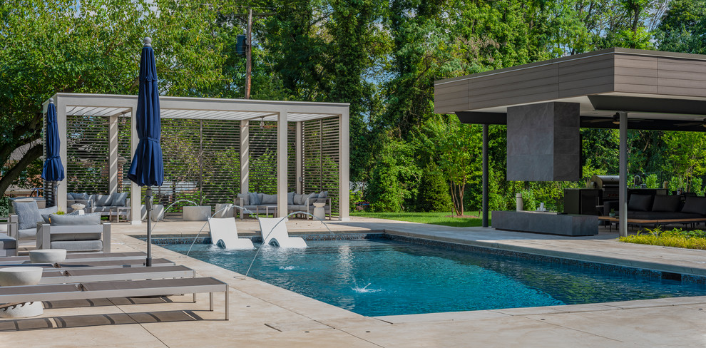 Diseño de piscina con fuente alargada actual rectangular en patio trasero